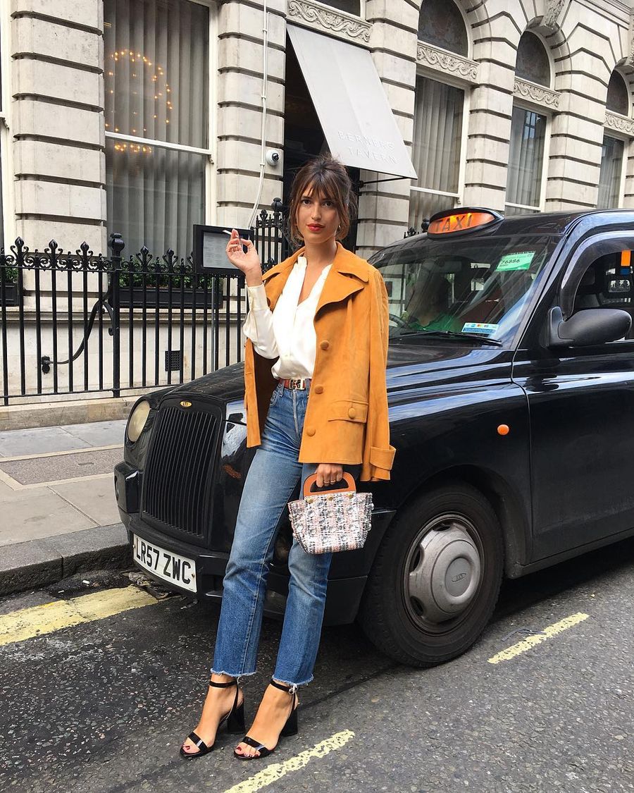 Jeanne Damas in London wearing a Tory Burch yellow jacket and straight leg jeans